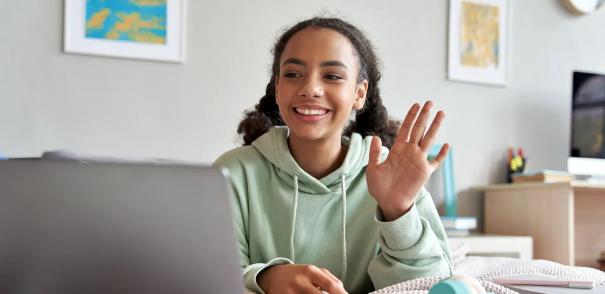 Student wearing a light green hoodie attending to an online class